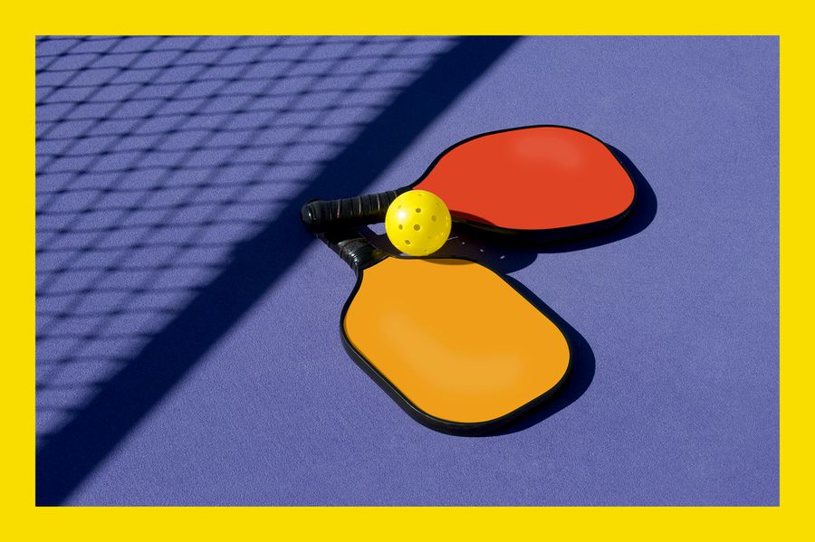 Pickleball - 2 paddles and ball sitting near net shadow