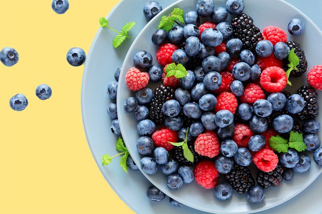 TikTok nature's cereal, Fruit salad with blackberry, blueberry, raspberry and mint leaves on wooden gray background. Flat lay. Top view