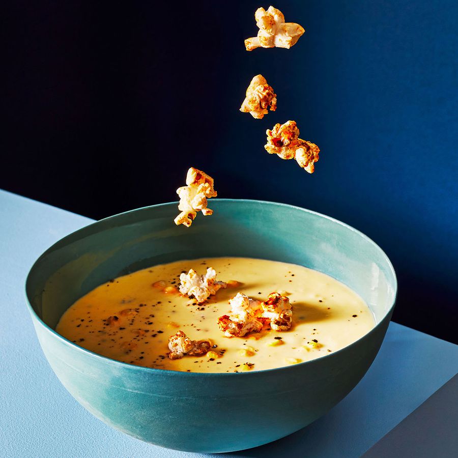 spiced popcorn dropping into bowl of creamy corn chowder